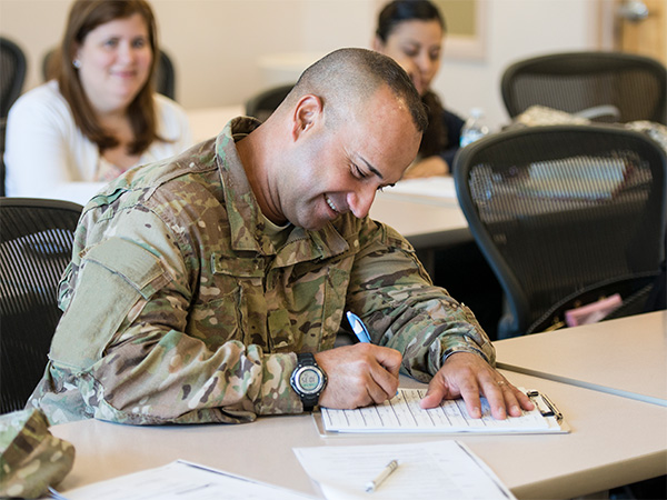 student in military uniform taking test in classroom