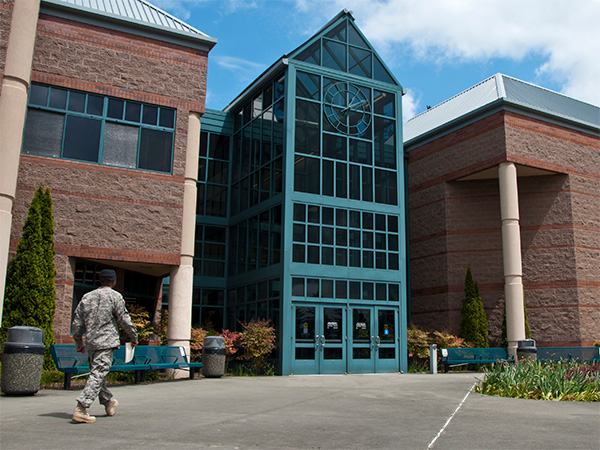 student in military uniform walks towards building