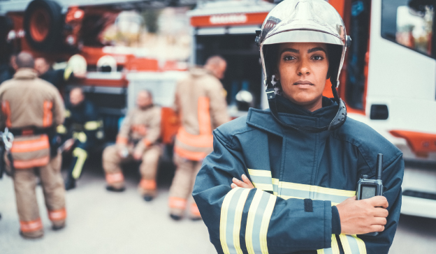 woman in protective fire gear in front of emergency vehicles Nurse and patients