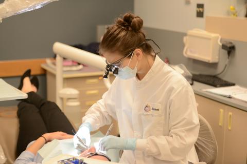 Dental hygiene student working with patient