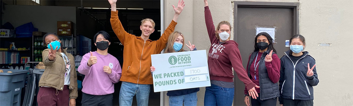 students at food bank holding achievement sign