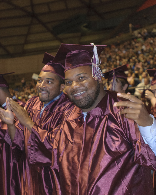 graduates at commencement wearing caps and gowns