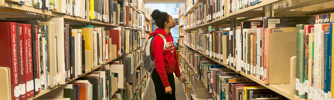 student browses through library books