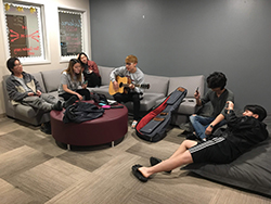 students playing guitar in the lounge