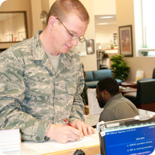 student in military uniform filling out form at counter