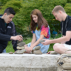 Students stacking rocks outside the College Center Building