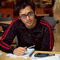 student at desk with pen and calculator