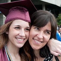 daughter in graduation attire hugging mother