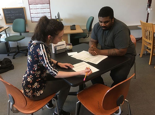 student and tutor working together at table in puyallup writing center
